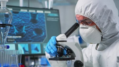 Close Up of Man Scientist Looking Through a Microscope