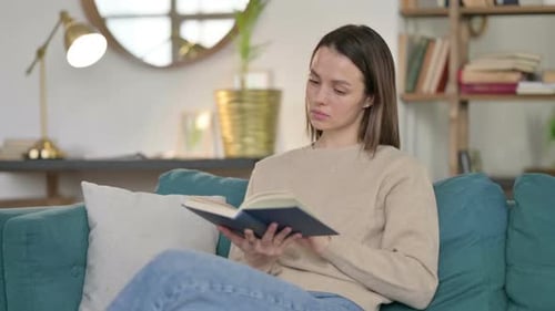 Woman Relaxing on Sofa Reading Book