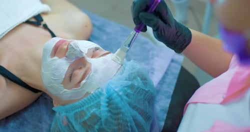 Woman Receiving Facial Mask Treatment at Spa
