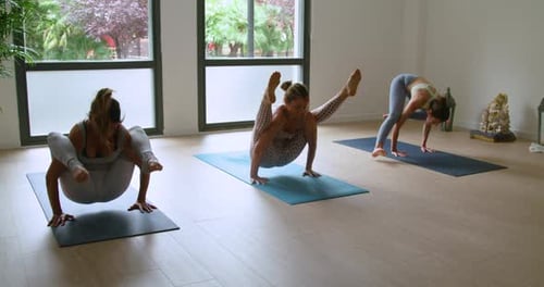 Les sportives améliorent la concentration tout en faisant la pose de yoga Tittibhasana