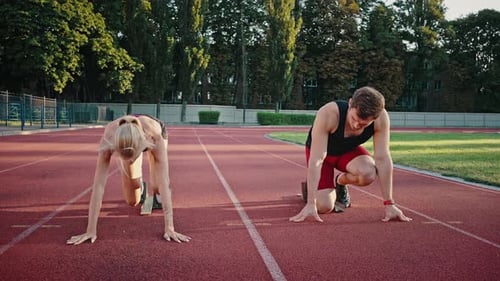 Fit Adults Sprinting From Blocks on Running Track