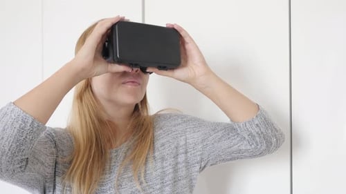 Blonde woman in white space trying virtual reality glasses 4K 2160p 30fps UltraHD footage - Blond f