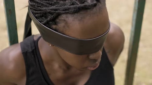 black african woman with eyes covered by a black ribbon.blindness,captivity
