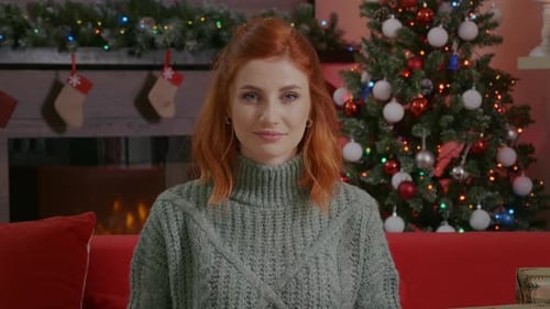 Woman Smiling in Front of Decorated Christmas Tree