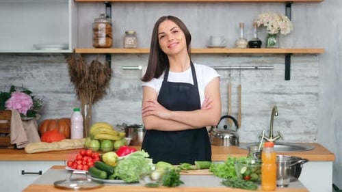 Smiling Woman with Fresh Vegetables in Kitchen