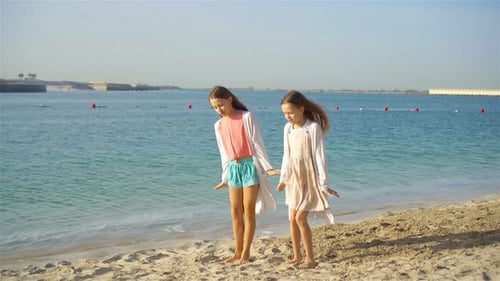 Little Happy Funny Girls Have a Lot of Fun at Tropical Beach Playing Together. Sunny Day with Rain