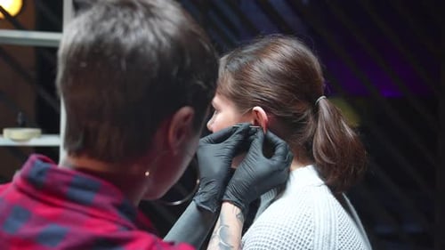 Woman Getting Ear Piercing in Studio