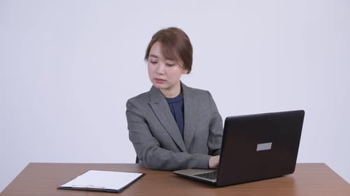 Young Woman Typing on Laptop in Office