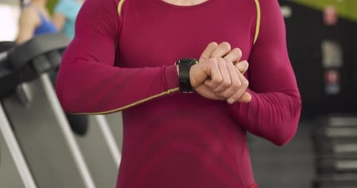 Athletic Man Using Smartwatch at the Gym