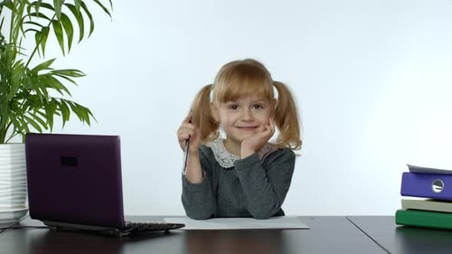 Cute Girl Smiling at Desk With Computer and Folders
