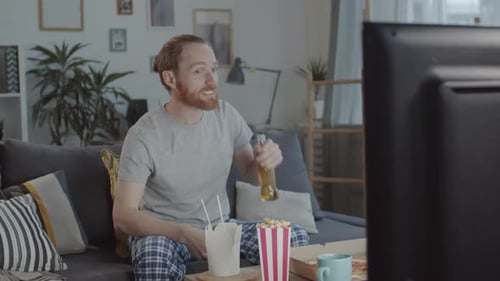 Red Haired Man Relaxing at Home Watching TV