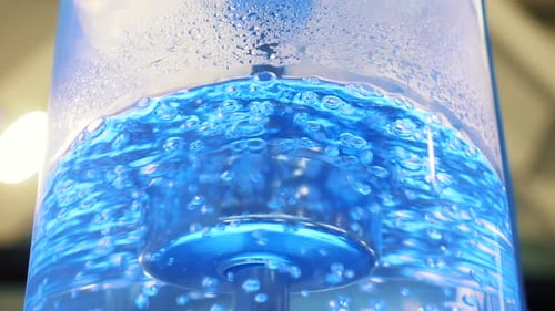 Agua hirviendo en un enfriador de vidrio grande