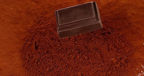Chocolate Tablet falling on Black Chocolate Powder, Slow motion 4K