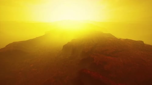 Flying Over Barren Rocky Landscape with Intense Golden Light