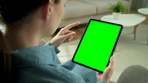 View From the Shoulder of Woman Holding and Using Hand Gestures on Green Mock-up Screen Digital