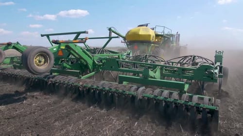 Tractor Cultivating Soil on Farm Field