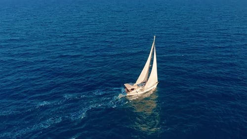 Sailboat in the Ocean. White Sailing Yacht in the Middle of the Boundless Ocean. Aerial View