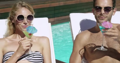 Couple Lounging by Pool with Colorful Cocktails