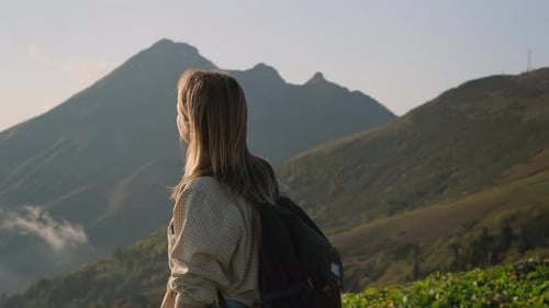Young Woman is Standing on Top of Mount or Hill and Admiring Landscape