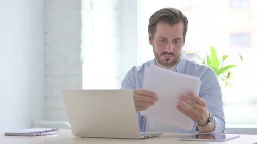Frustrated Man Working At Desk in Office