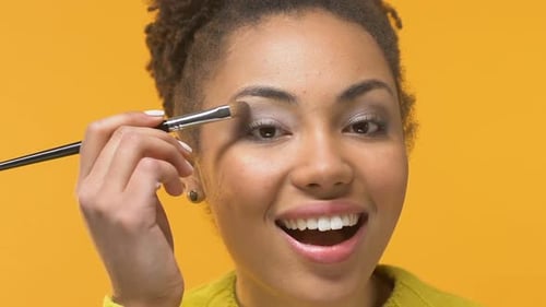 Smiling Woman Applying Eye Shadow with Brush