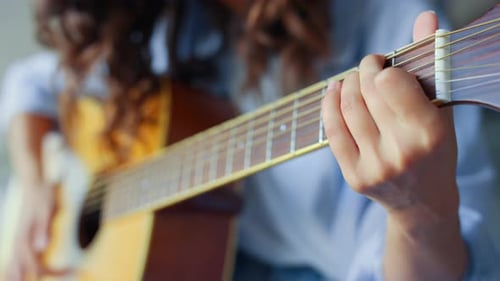 Young Adult Playing Acoustic Guitar at Home