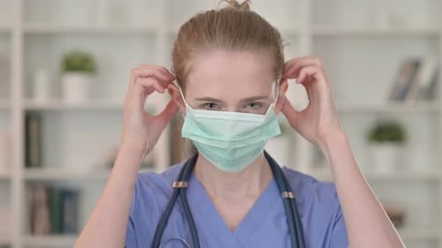 Cautious Young Female Doctor Wearing Protective Face Mask