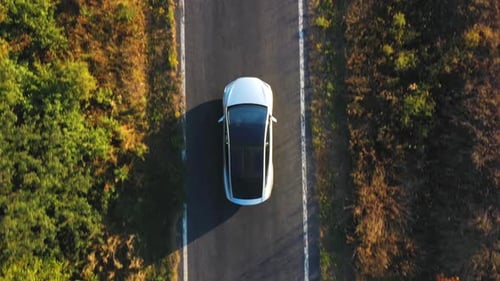 Aerial Shot of Electrical Car Driving on Country Road at Summer Evening. New SUV Vehicle Moving Fast