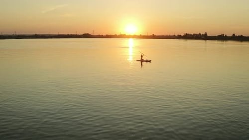 Paddleboarder on Water at Sunrise Silhouette