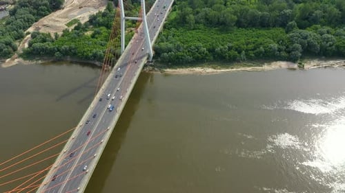 Aerial shooting from flying drone car traffic on modern highway bridge over river