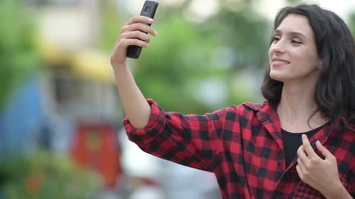 Woman Poses for Selfies in Urban Setting
