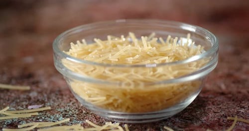 Pâtes sèches et vermicelles dans un bol en verre à rotation lente