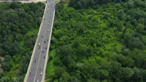 Aerial shooting from flying drone car traffic on modern highway bridge over river