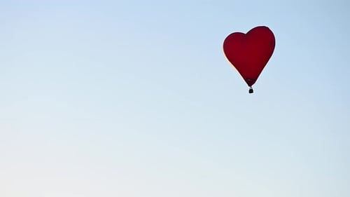 Red Heart Balloon Flying into Blue Sky