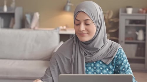 Portrait of Young Muslim Woman with Laptop at Home