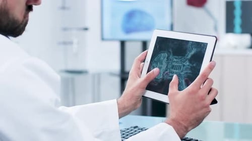 Arzt betrachtet und analysiert eine Röntgenaufnahme auf einem digitalen Tablet-PC-Bildschirm