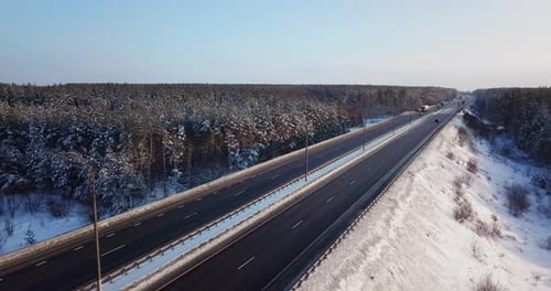 Blick von oben auf eine Autobahnstraße mit Autos und Lastwagen auf der Straße im Winter