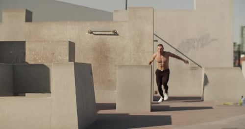 Shirtless Man Doing Parkour on Urban Obstacle Course