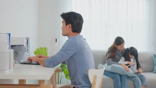 Family at Home Using Technology in Bright Living Room