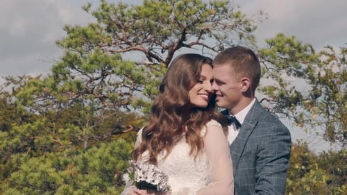 Newlywed Wedding Couple Walking in the Park. Two Young People in Love Meet Each Other's Eyes