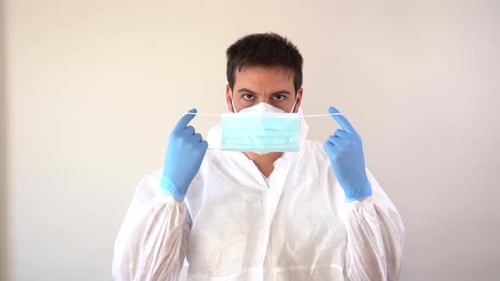 Young Adult Putting On Protective Surgical Mask
