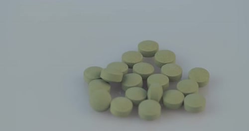 Pile of Round Light Green Pills Rotating