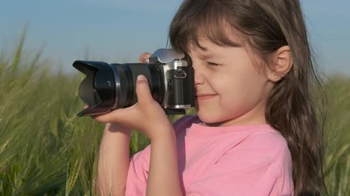 Girl Taking Photographs With Camera In Field