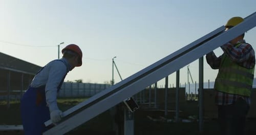 Drei Arbeiter installieren ein Solarpanel