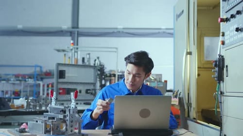 Engineers Using Laptop in Modern Factory Workplace