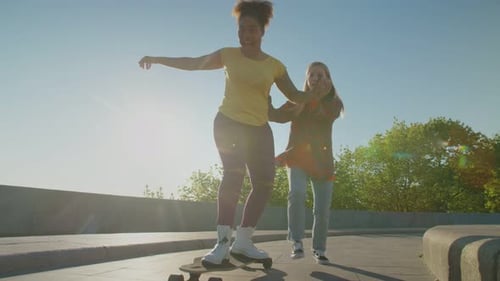 Women Learning to Skateboard in Sunlight
