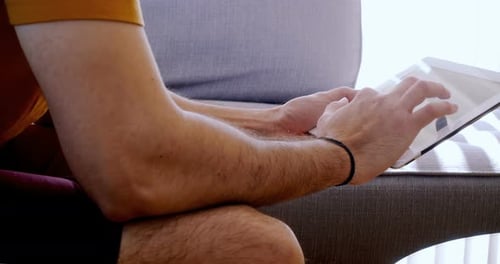 Adult Using Tablet Device Sitting Indoors