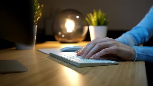 Woman Typing on Keyboard at Night