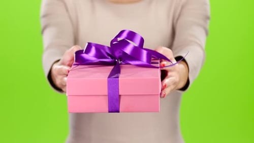 Girl Holding Out a Box with a Gift. Studio