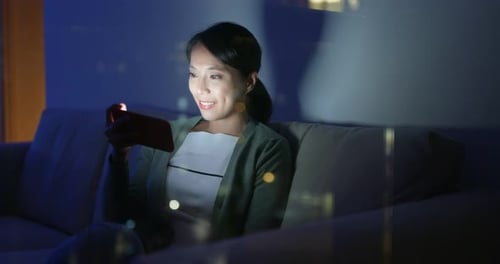 Woman Using Mobile Phone at Night Indoors